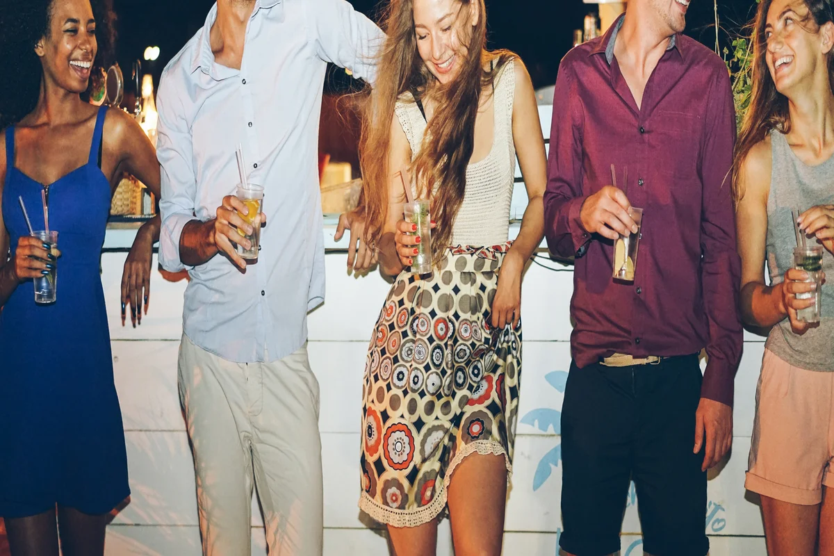 Friends toasting colorful patriotic cocktails at a 4th of July bar crawl