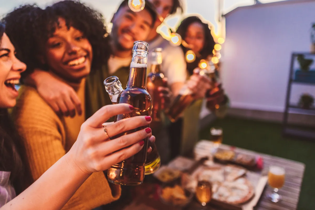 Friends toasting beers at a summer Independence Day bar crawl