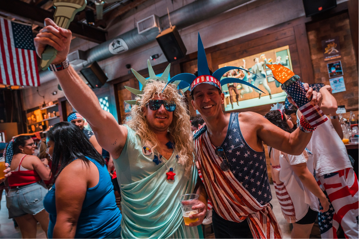 A girl dancing in the bar at a bar crawl in the summertime.