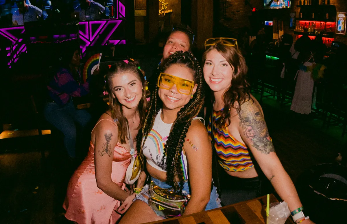 four girlfriends dressed in rainbow flags enjoy a night out at the pride bar crawl