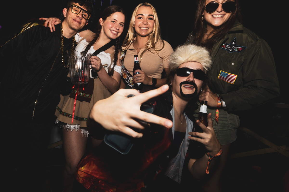 friends wearing halloween masks at a halloween bar crawl dressed up in costume