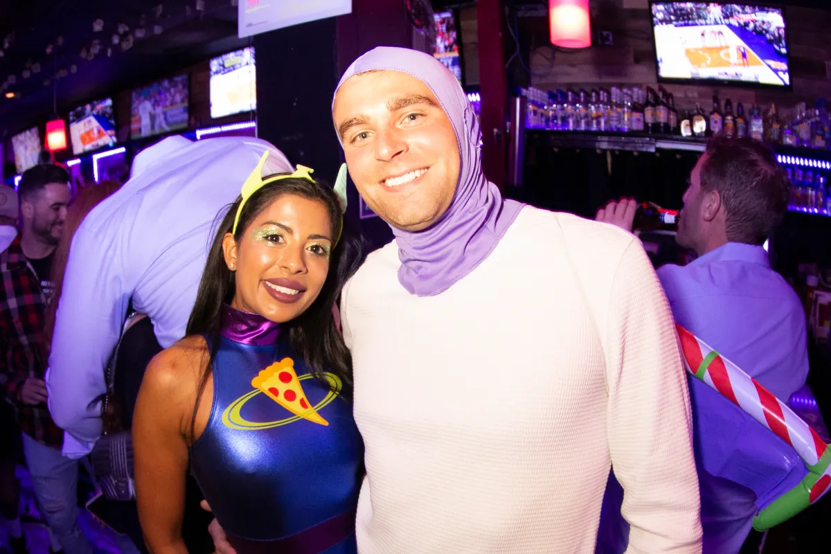 A guy and girl dressed in halloween costumes take photos at the official halloween pub crawl