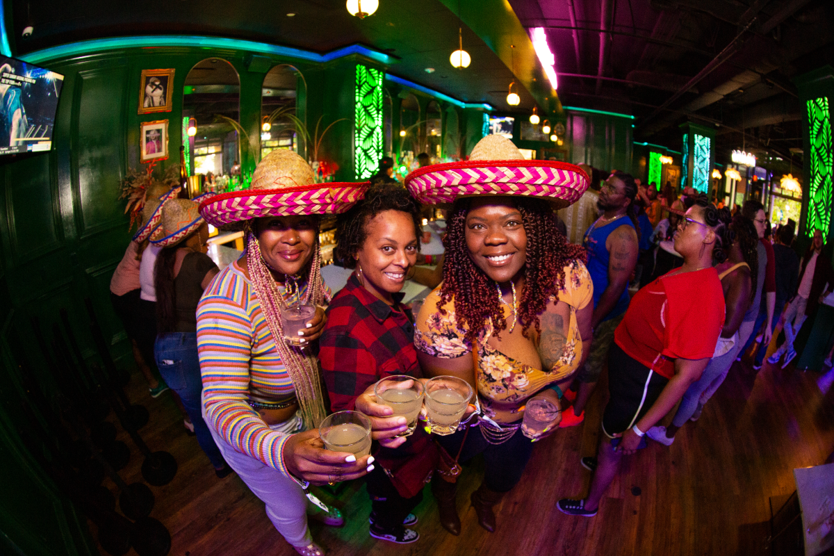 friends wearing sombrero hats at a taco and tequila bar crawl