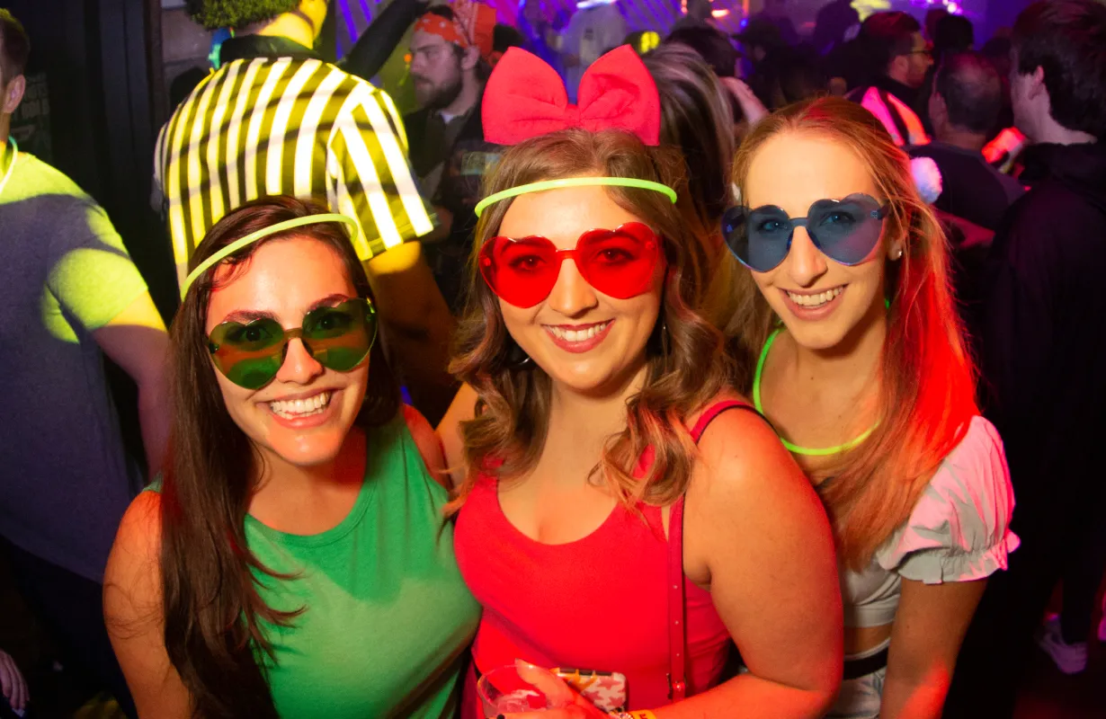 3 girls pose for the camera showing off their halloween costumes at the offical halloween bar crawl