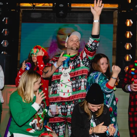 Friends in christmas sweaters captured candidly during the ugly sweater bar crawl in Baltimore