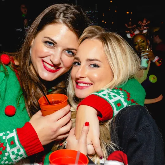 Laughing all the way: festive group navigating the ugly sweater bar crawl in style.