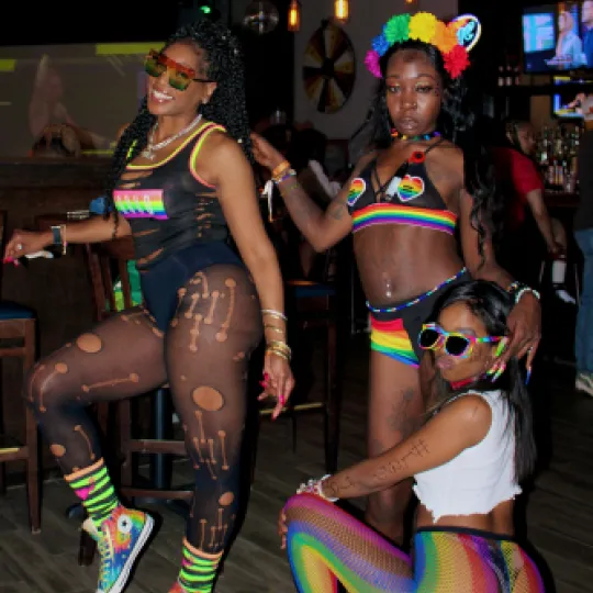 3 girls getting low at the Pride Bar Crawl showing off their true and colorful sex appeal