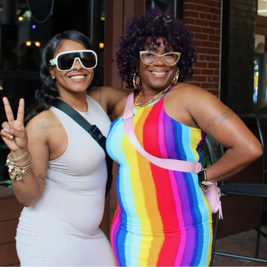 Rainbow-clad duo smiling and making the Bar Crawl unforgettable showcasing the best of Pride Month
