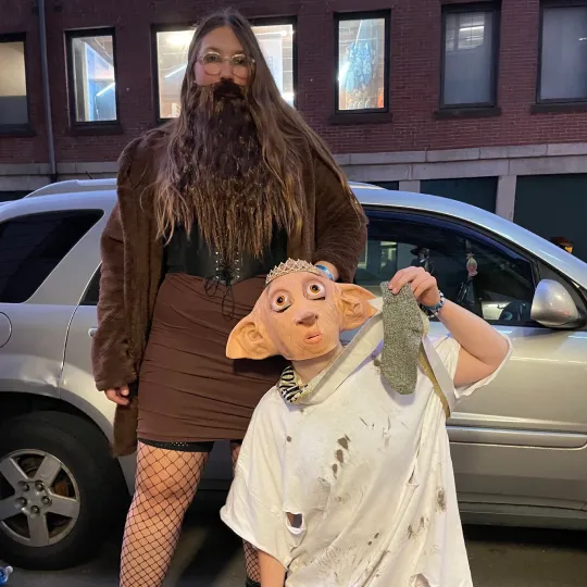 A hillarious and creative group of 2 friends at the halloween bar crawl showing off their harry potter themed halloween costumes as Dobby the Elf and Hagard
