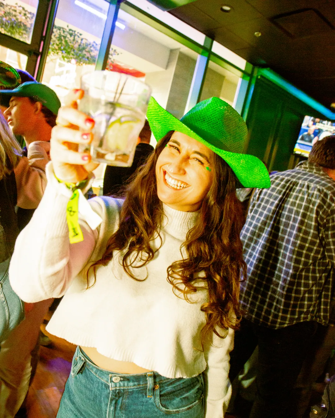 Warm-hearted girl in green, toasting to the Irish during the St Patricks bar crawl