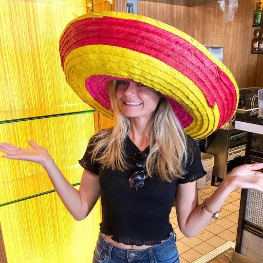 A girl with a sombrero hat standing in front of a bar during the tacos and tequila bar crawl