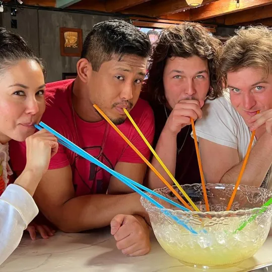 Group of friends chug margaritas, each with their own straw in a giant bowl during the margarita bar crawl