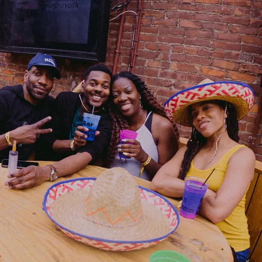 Group of enthusiastic bar crawlers, sharing tales and toasts at the vibrant Tacos and Tequila bar hop