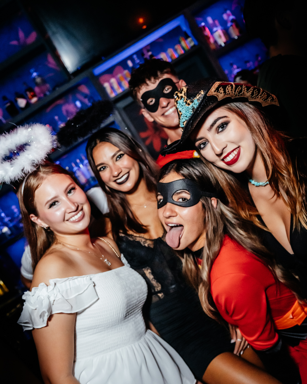 Beneath the bar's dim lighting, a fun friend pair dressed in Mario Cart costumes dance amonst a diverse range of Halloween disguises during the Halloween Bar Crawl
