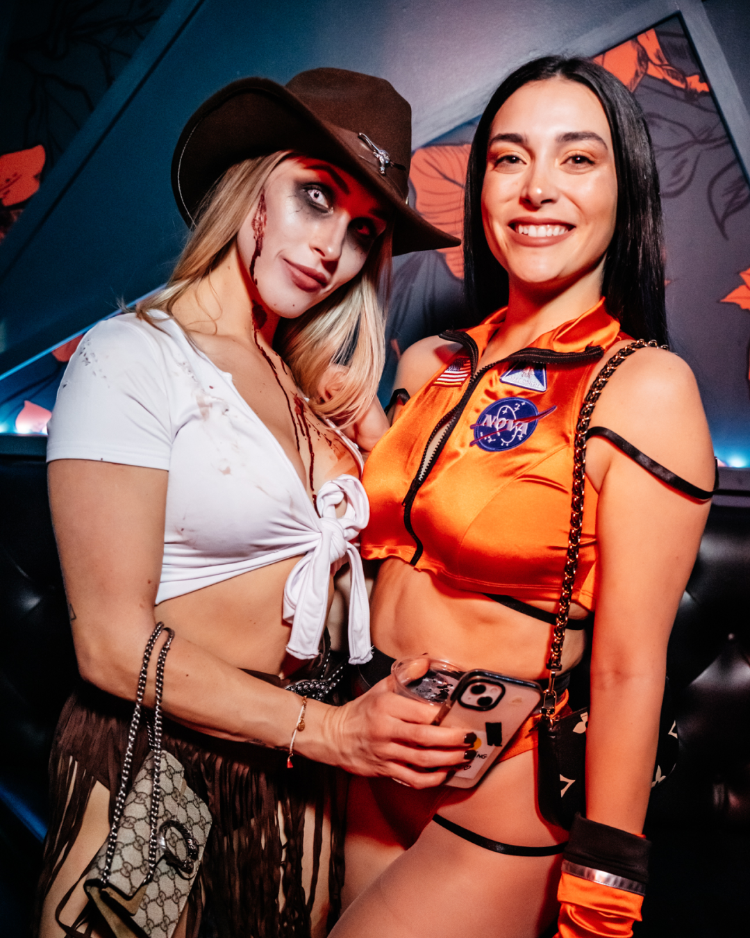 Beneath the bar's dim lighting, a fun friend pair dressed in Mario Cart costumes dance amonst a diverse range of Halloween disguises during the Halloween Bar Crawl
