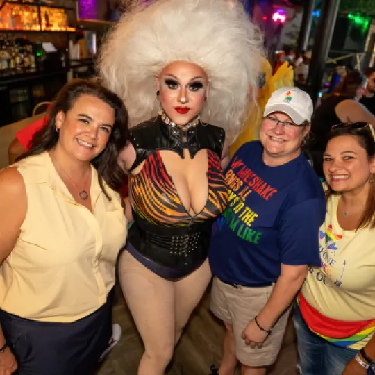 Group of Pride Bar Crawlers stand with the Drag Queen after the drag show showing love and support of Pride Month