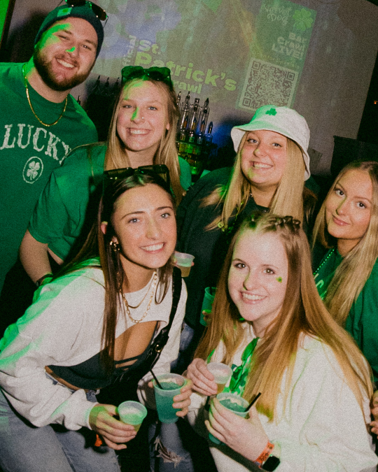 a group of friends at the St. Patrick's day bar crawl pose a ppicture in river north
