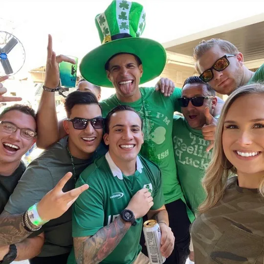 Group of friends, one wearing a large green hat,at the St Patricks Bar Crawl in Chicago 