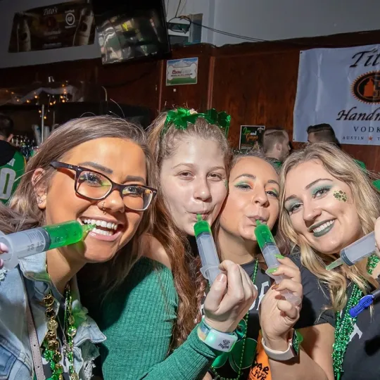 Cherished moments as besties suck down green jello shots in St. Patrick's themed attire at the St Paddys bar crawl
