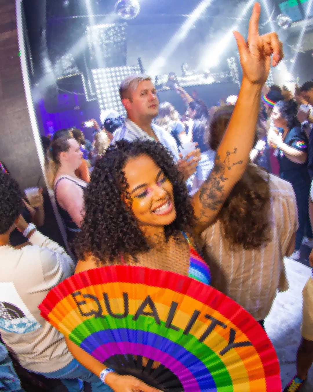 Girl holding up an equality fan showing her support during the Pride Bar Crawl
