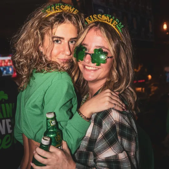 Girlfriends in creative green ensembles, from sparkling shamrock beads to green-tinted glasses, becoming the heartbeat of the St. Patrick's Day bar fest
