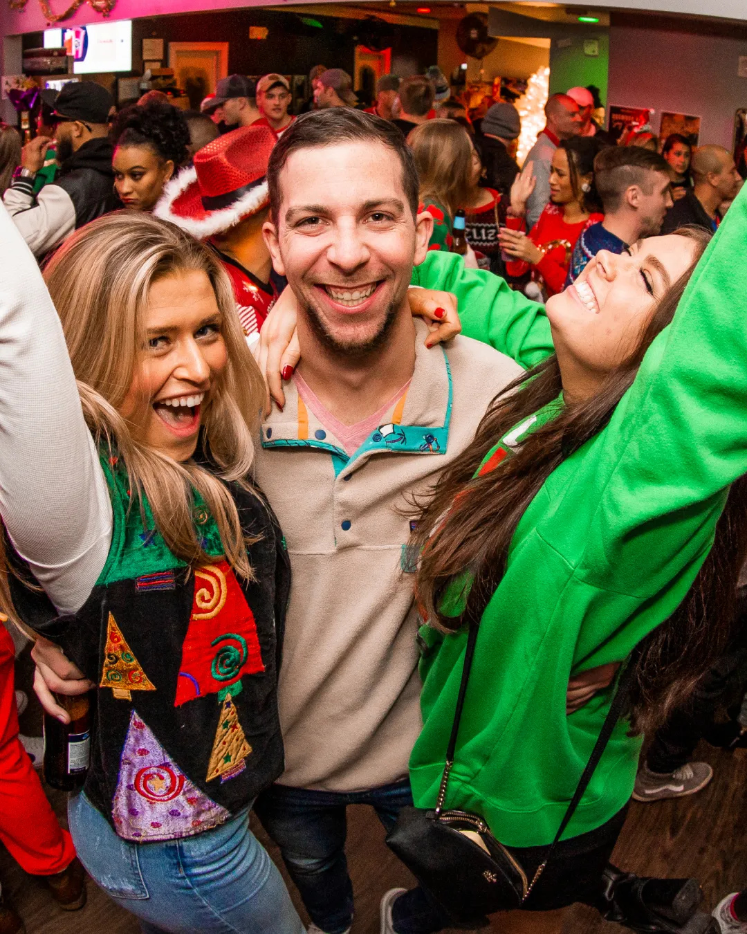 Cheerful friends clinking glasses at the ultimate Christmas sweater party.