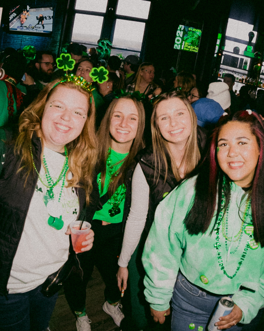 a group of friends in greektown, detroit pose for a picture during the st paddy's day bar crawl