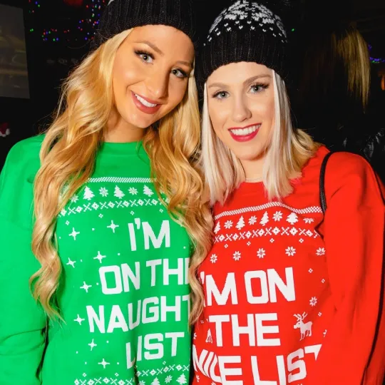 2 gorgeous girls rocking their crew necks that says "On the Naughty List" at the christmas holiday bar crawl