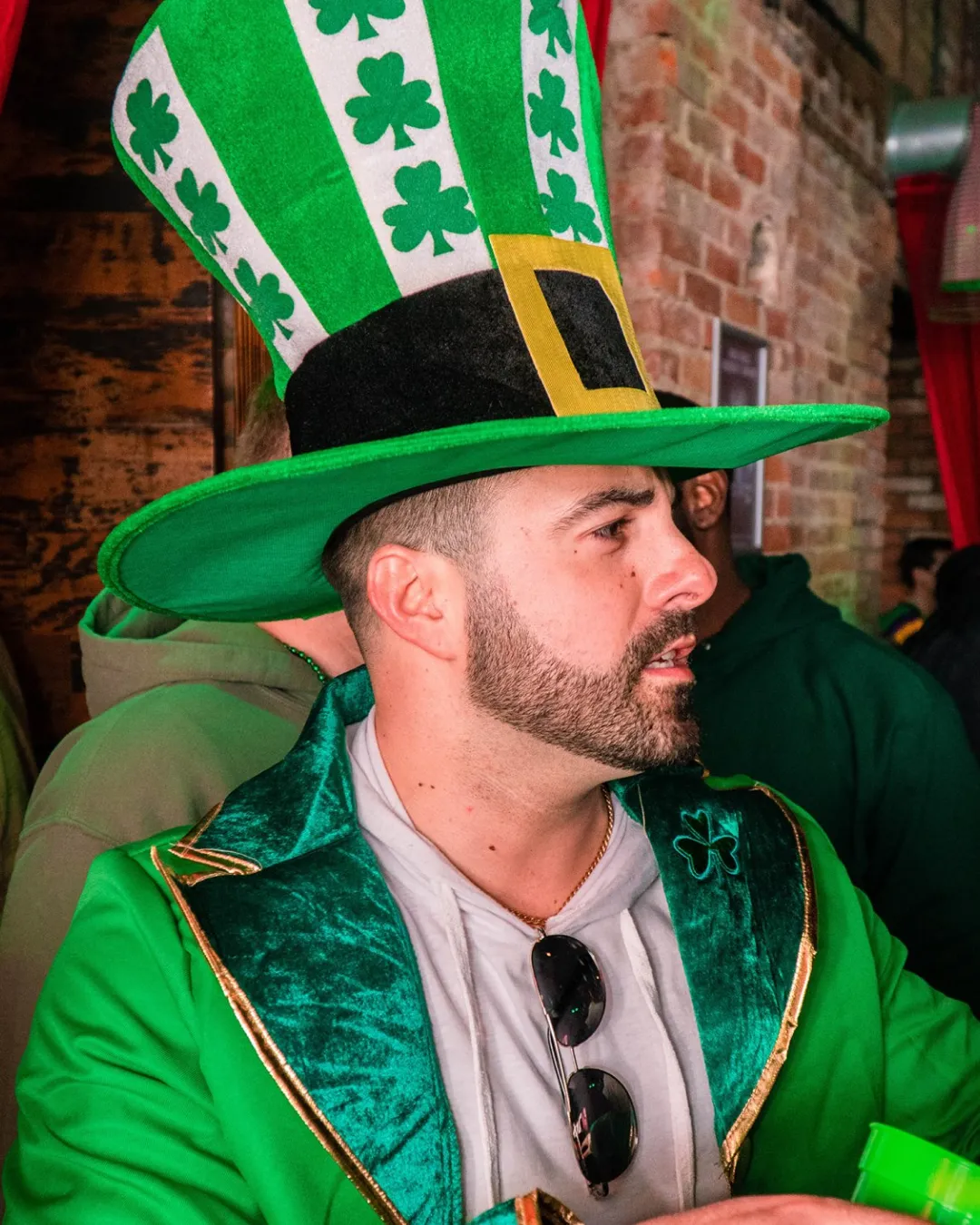 Young gent in a st patricks day hat moves with energy  through the club's vibrant bar scene during the St Paddys Day Bar Crawl in Hoboken

