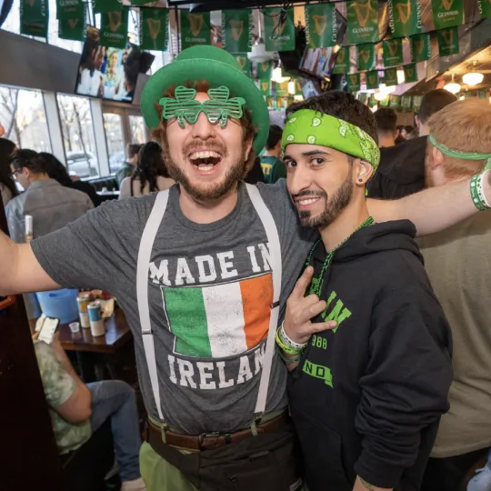 Heartfelt moments are made as friends in Irish-themed garb exchange toasts, their camaraderie shining bright in the bar crawl's festive vibe
