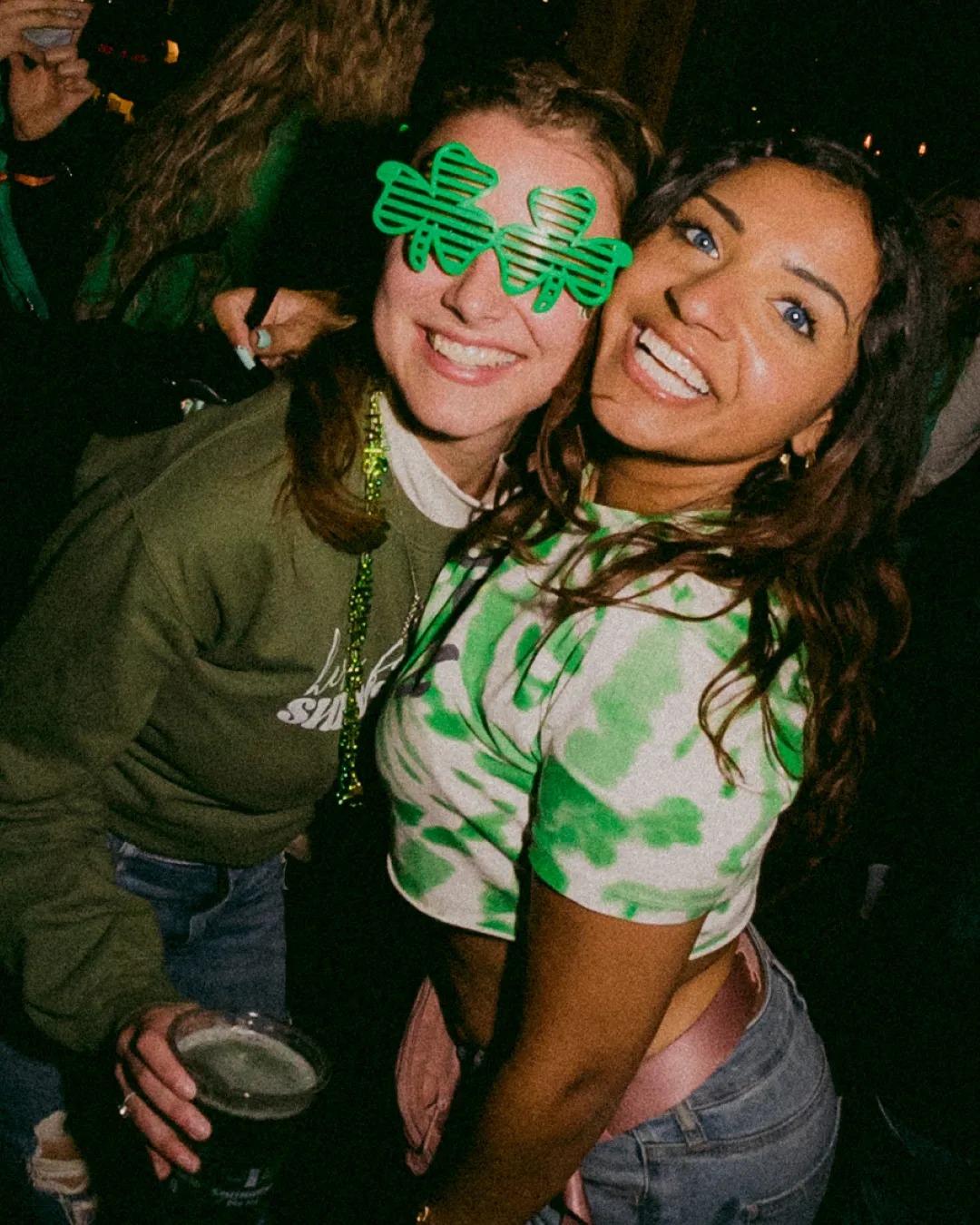 Lively ladies lighting up the scene with their green st patricks themed outfits and shamrock glasses diving into the festive spirit of the irish bar crawl
