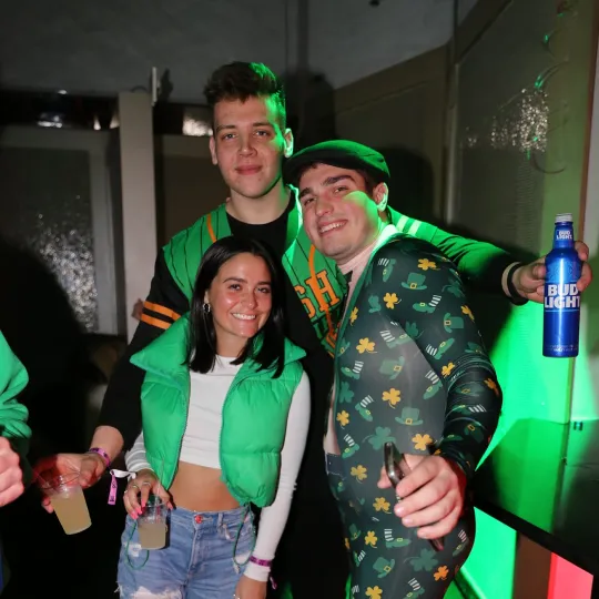 A group of friends smiling at the camera during the St Pats bar crawl wearing green themed outfits