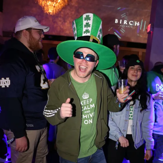 Solo dancer in chic green attire, moving with unmatched grace and energy to the club's pulsating beats during the st pats bar crawl
