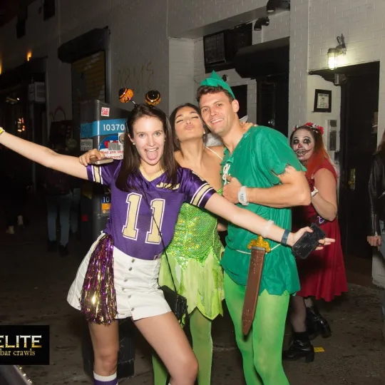 Surrounded by an ambiance of haunting melodies, a crew of friends dazzles, each costume telling a unique tale against the backdrop of the lively Halloween bar crawl

