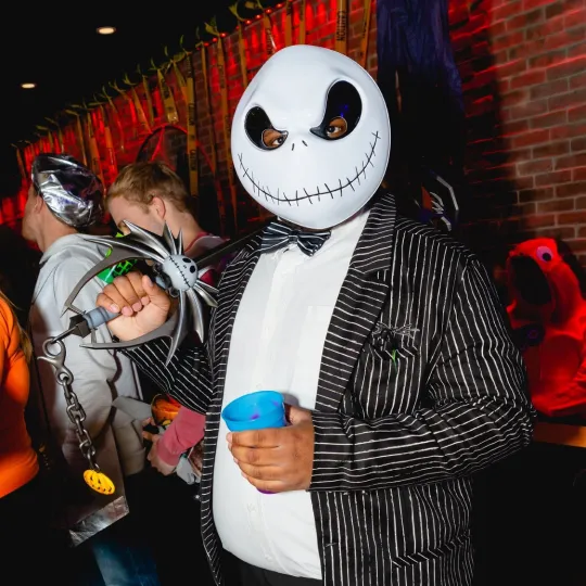 Confident club-goer in a sleek Tim Burton Halloween Costume ensemble during the Halloween Bar Crawl
