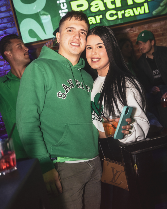 a couple posing for a picture during the philadelphia st patricks day bar crawl
