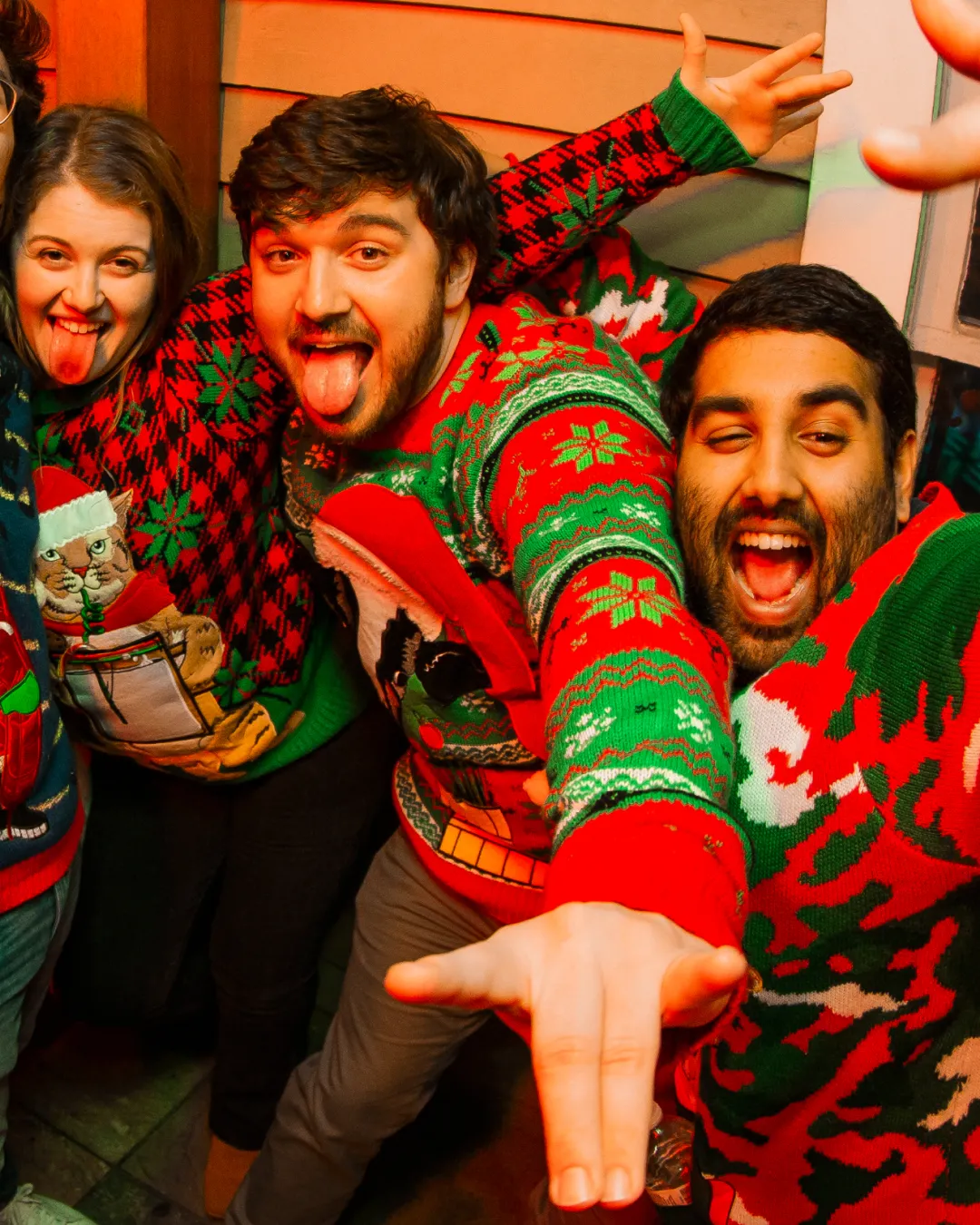 Bar crawl participants raising a toast in their wild holiday attire at the Ugly Sweater Bar Crawl