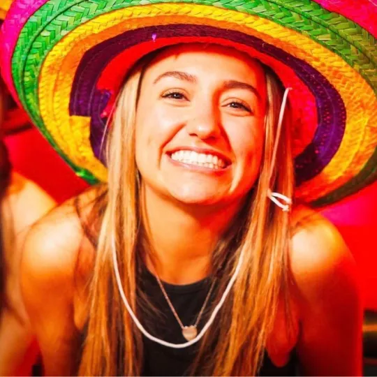 Girl smiling at camera wearing a sombrero hat during the tacos and tequila bar crawl