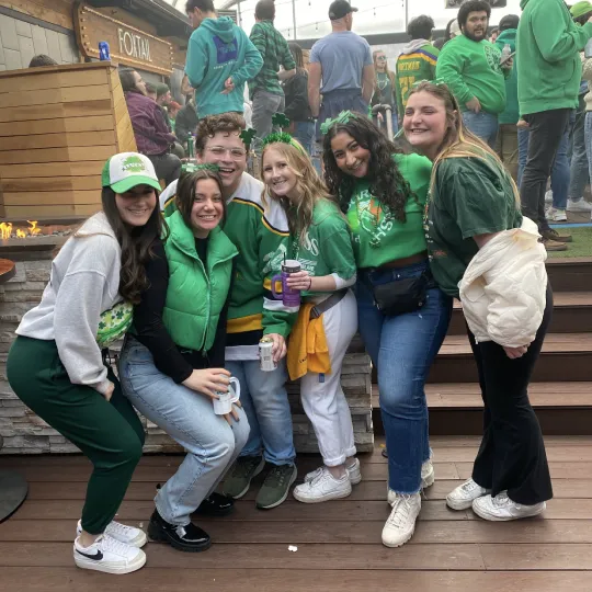 A group of friends at Skybar in Pittsburgh during the St Pats bar crawl wearing green outfits having fun