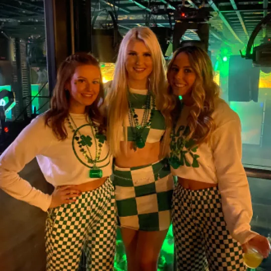 Enthusiastic friends, their St. Patrick's outfits shimmering under the bar lights, navigating the vibrant venues with infectious energy

