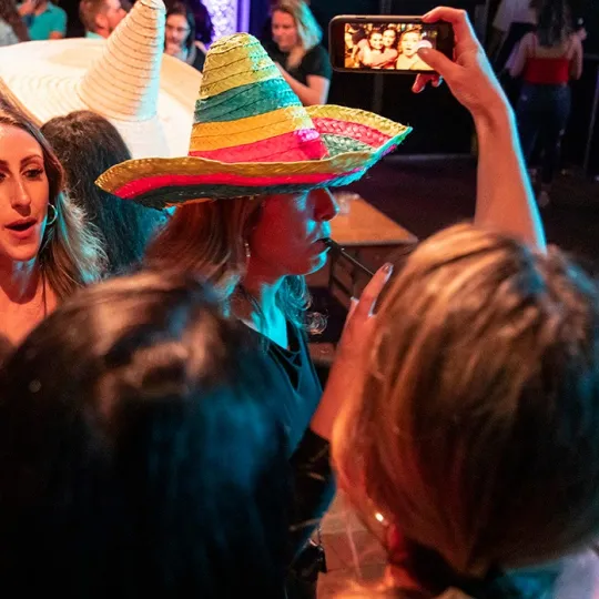 Girl in sombrero hat enjoying the vibe of the tacos and tequila bar crawl