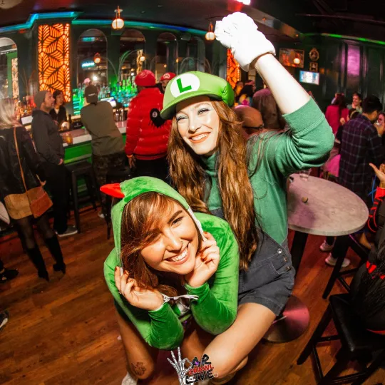 Young pair laughing in their Luigi and Mario themed themed halloween costumes at one of the best nightclubs in Raleigh at the Halloween bar crawl
