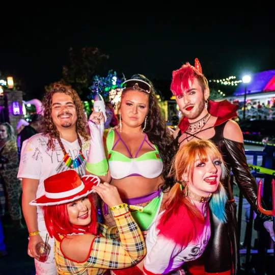 The bar's rhythmic pulse finds its match in a lively ensemble of friends, each Halloween outfit contributing to a vivid tapestry of spooky spirit at the Halloween Bar Crawl

