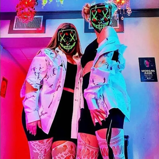 2 girlfriends show off their matching Halloween Costumes rocking a bloody zombie costume and LED light up face masks.