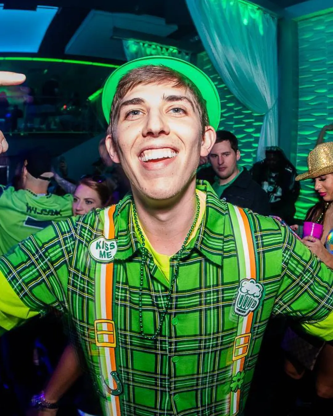 Energetic young man in vibrant green attire, enjoying the bustling st patricks day energy at the bar crawl in Raleigh
