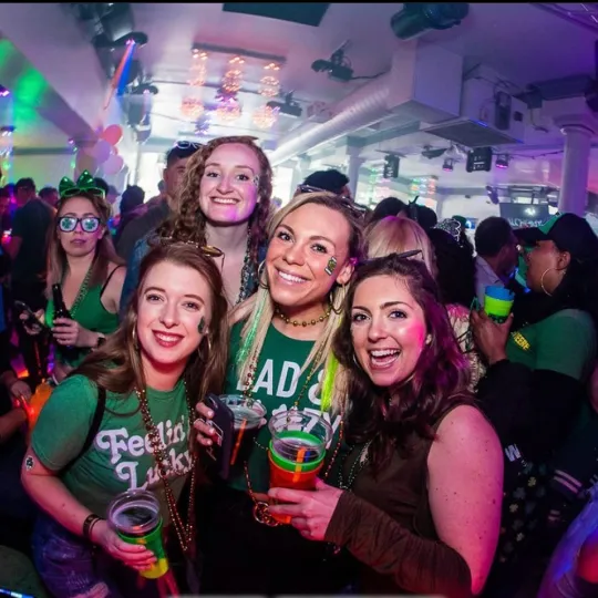 A group of girlfriends having a blast at the St Paddys bar crawl in Raleigh wearing their most green outfits