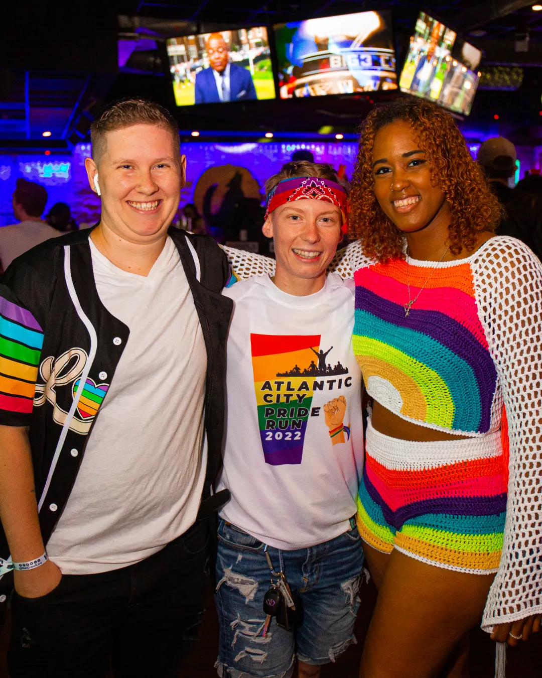 Friends capturing memories with rainbow-themed outfits at the Pride Bar Crawl

