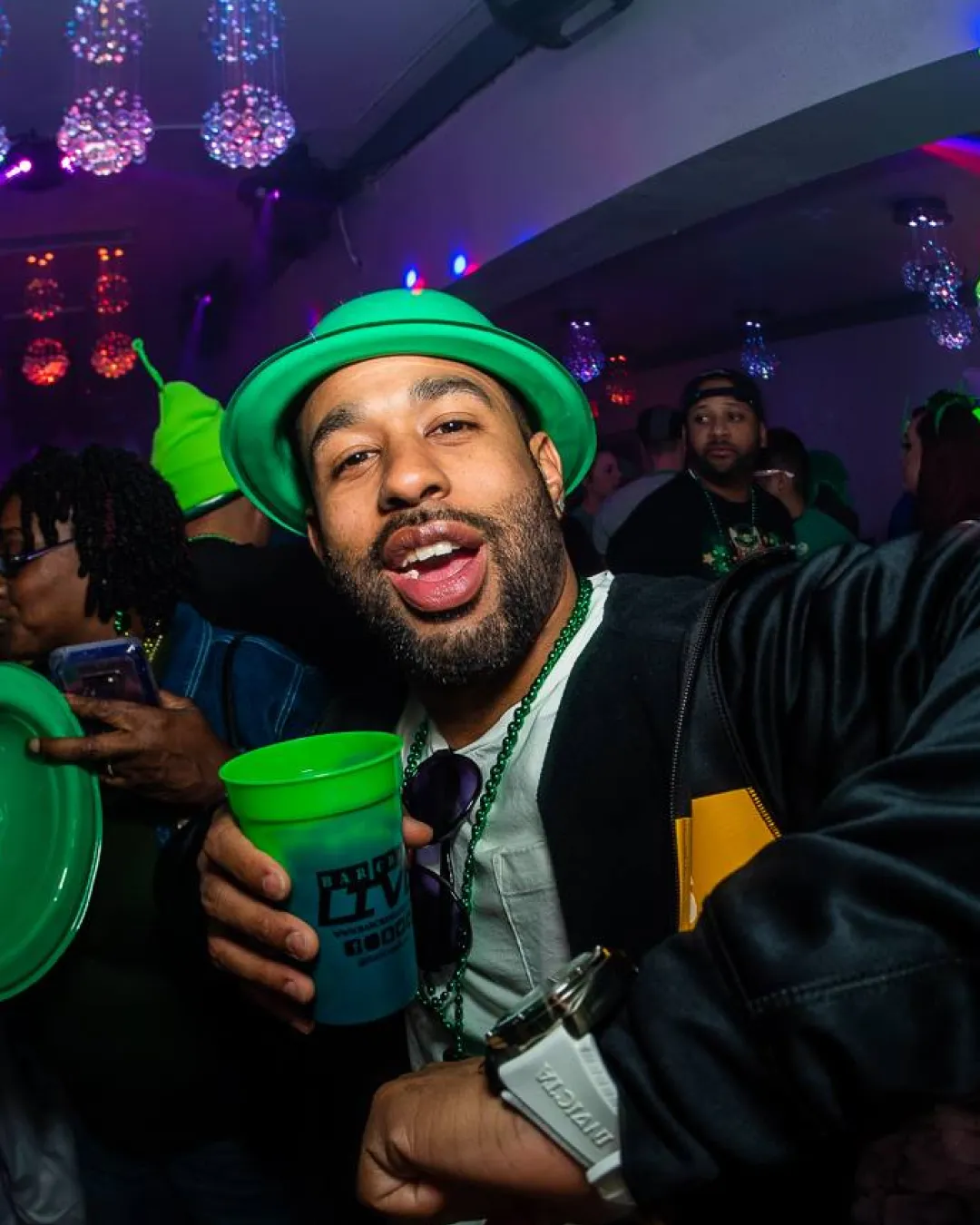 Gentleman dressed in a classic st pats bucket hat lost in the rhythm and lights of the city's most happening nightclub during the bar crawl
