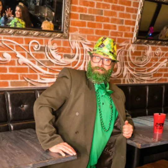 Fashion-forward club-goer standing out, with an original St Paddys Day Irish outfit that mirrors the luxe interiors of the nightclub
