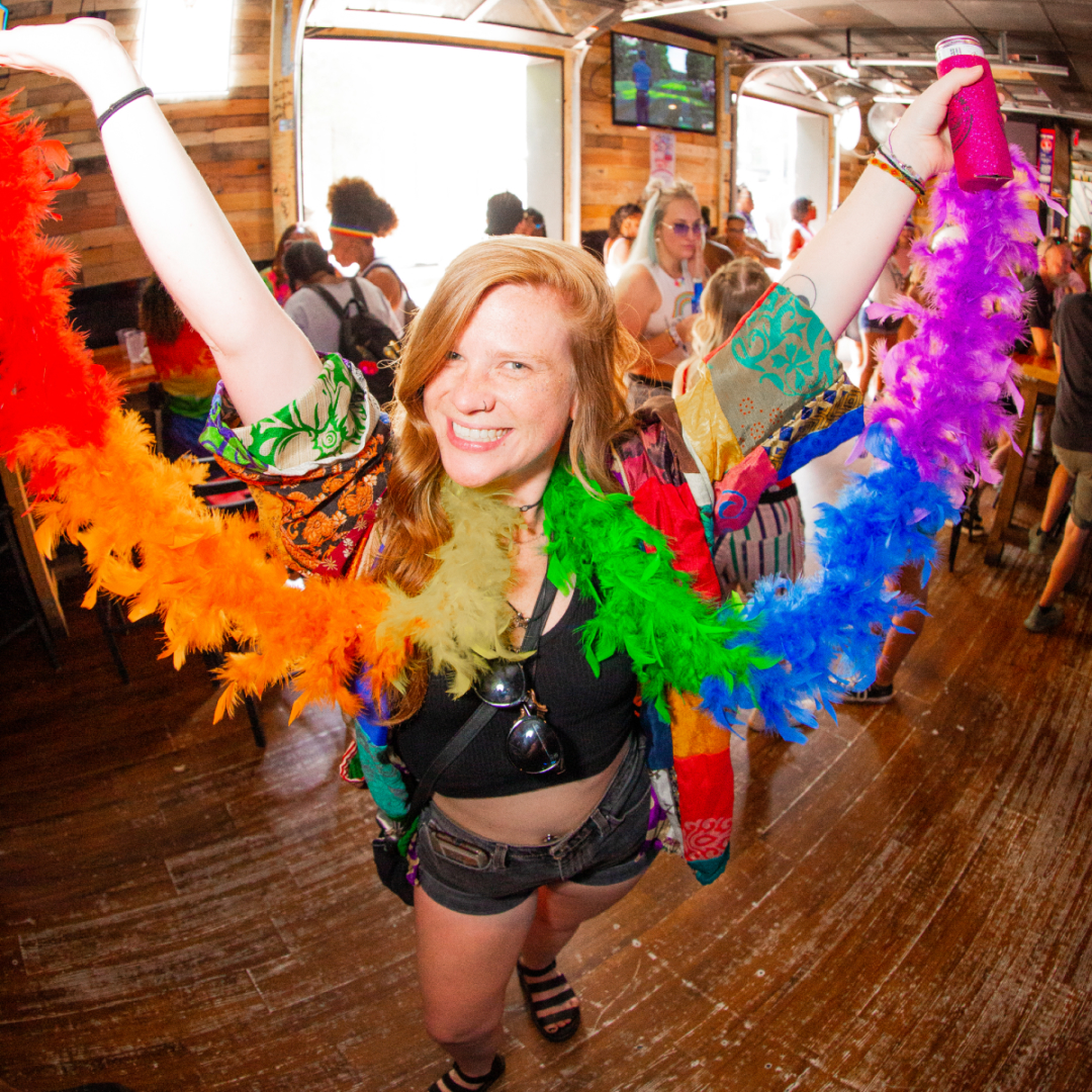 Girl wearing a rainbow feather boa scarf celebrating pride at the bar crawl in Charlotte